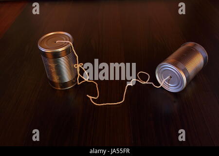 A retro homemade toy telephone made from two empty metal cans and a string Stock Photo