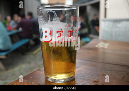 A pint glass with the word 'Beer' on it in the outside garden of a pub in Oxford, England, United Kingdom. June 2, 2017. Stock Photo