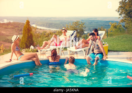 Young group enjoying in swimming pool at summer Stock Photo