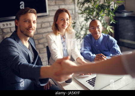 Welcome aboard! businessman shaking hands - you got the job in the team Stock Photo