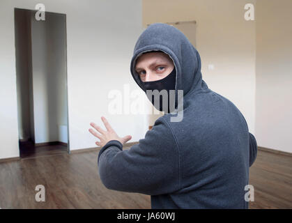 masked thief in house Stock Photo