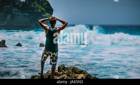 Man Provoke Ocean Waves on Tembeling Coastline at Nusa Penida island, Bali Indonesia Stock Photo