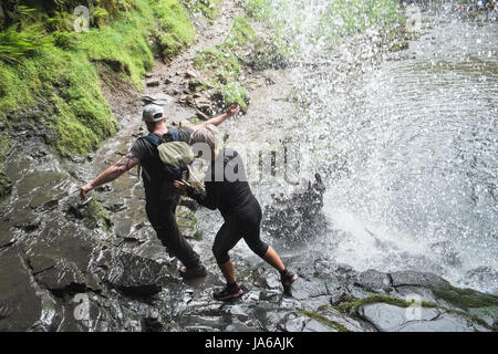 People,hiking,walk,behind,beneath,waterfall,Sgwd yr Eira,Waterfall of the Snow,Afon Heptse,river,Powys,Brecon Beacons,National,Park,Wales,Welsh,U.K,UK Stock Photo