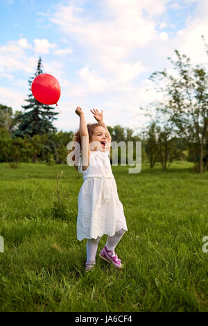 Child with an inflatable ball is playing in the park. Stock Photo