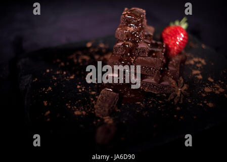 One red straberry on a dark  chocolate Stock Photo