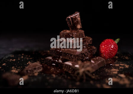 One red straberry on a dark  chocolate Stock Photo