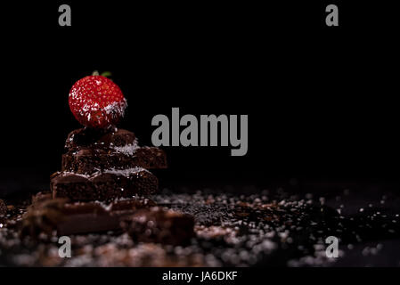 One red straberry on a dark  chocolate, crushed.Coconut chips Stock Photo