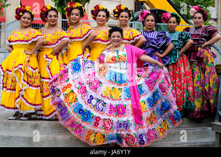 Group of Mexican mariachi female folk dancers wearing Mexican traditional sinaloa dresses, yellow dresses, Nayarid dresses, celebrating Mexico's cultural heritage, folkloric dance, group shot, looking at camera. Stock Photo