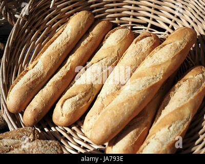 A few of baguettes in a wicker basket, fresh and fragrant, tasty warm, crusty French bread Stock Photo
