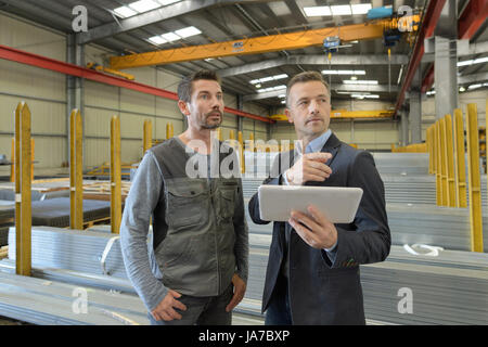 supervisor and manual worker using digital tablet in metal industry Stock Photo