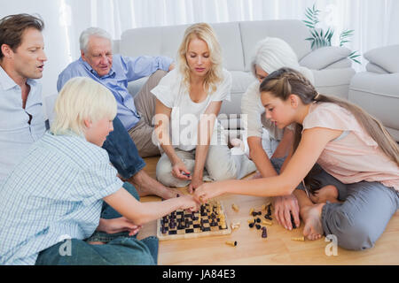 Extended family playing chess in the living room Stock Photo