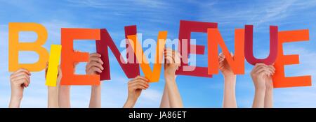 Many Hands Holding the Colorful French Word Bienvenue in the Sky Which Means Welcome Stock Photo