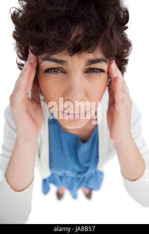 Overhead of woman with a headache touching her temples on white background Stock Photo