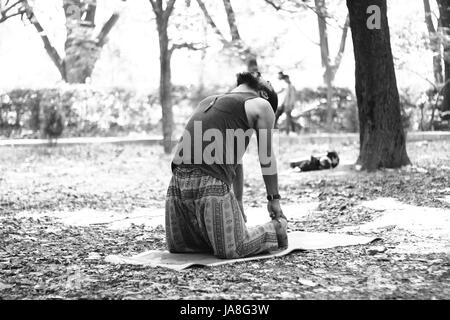 Young Indian man in camel pose (Ustrasana), in Cubbon Park, Bangalore. Stock Photo