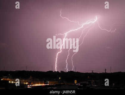 Multiple lightning bolts from a single source strike at night Stock Photo