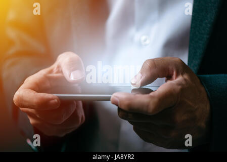 Businessman playing mobile app video game on smart phone, close up of male hands Stock Photo