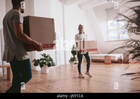 Moving to a new apartment. Young couple holding cardboard boxes. Stock Photo