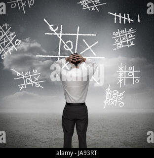 Anxious businessman losing at noughts and crosses with hands on head Stock Photo