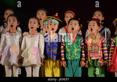 North Korea children performing music and dancing in the city of Rason. Songs hailing the 'Great' and 'Dear Leaders' Kim Il Sung and Kim Jong-Il. Stock Photo