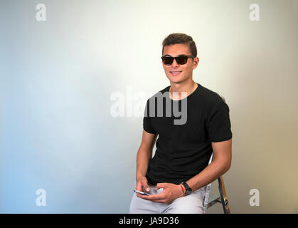 Young Latin man using mobile phone Stock Photo