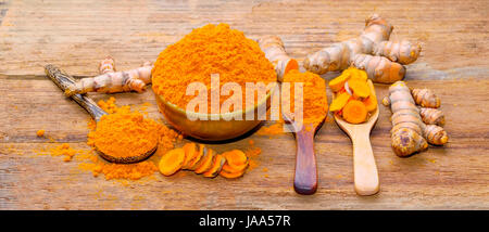 fresh turmeric roots on wooden table Stock Photo