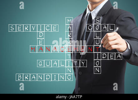Business man writing management crossword concept Stock Photo