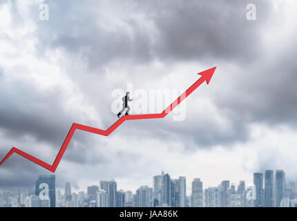 Young businessman running on chart arrow going up