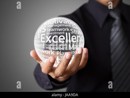 Businessman hand showing excellence word in crystal ball Stock Photo
