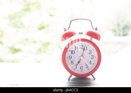 Red Alarm Clock in the Open Window. Stock Photo
