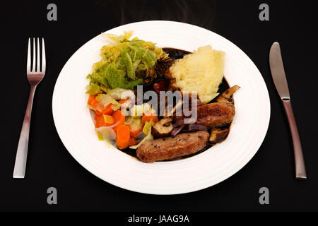 Sausage mashed potatoes cabbage carrots leeks with onion gravy Stock Photo