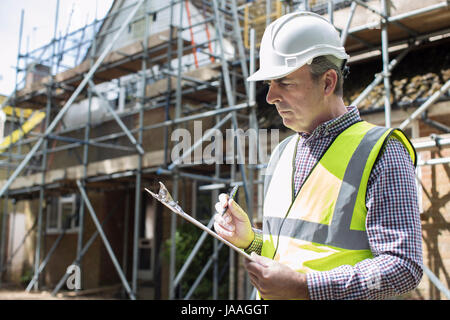 Building Inspector Looking At House Renovation Project Stock Photo