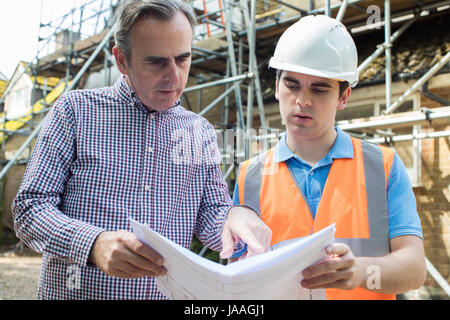 Customer On Site Discussing Plans With Builder Stock Photo