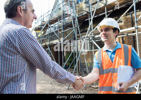 Customer On Site Shaking Hands With Builder Stock Photo