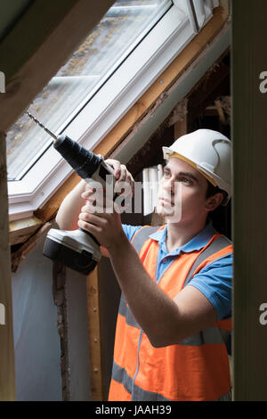 Construction Worker Using Drill To Install Replacement Window Stock Photo
