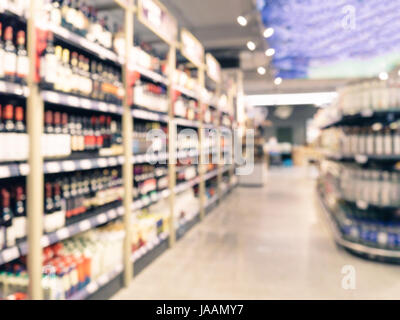 Abstract blurred supermarket aisle with colorful shelves and unrecognizable customers as background Stock Photo