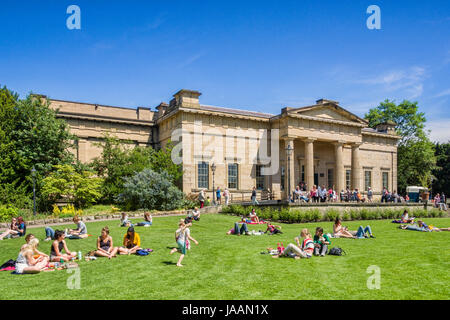 31 May 2017: York, North Yorkshire, England, UK - People of all ages relaxing on a sunny day in the Museum Gardens in front of the Yorkshire Museum in