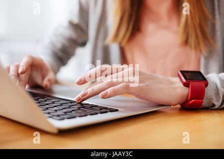 Casual hi-tech. Intelligent charming young lady using her gadget for fulfilling her assignment while preparing a draft of her study for professor Stock Photo