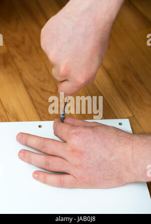 Man's hand using screwdriver. Close-up view. Stock Photo