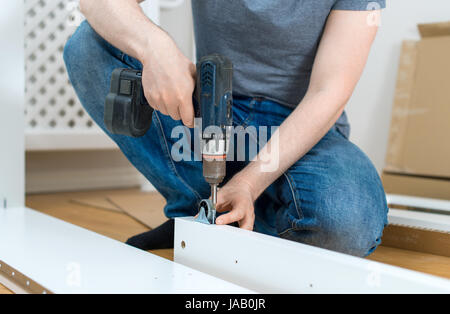 Repairman using screw gun. Close-up view. Stock Photo