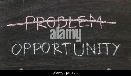 problems crossed out and opportunity on blackboard Stock Photo