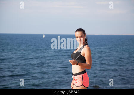 Fitness Sports girl listens to music with headphones Stock Photo