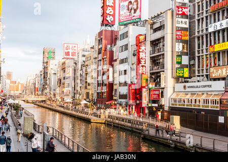 Dotonbori, one of the principal tourist destinations in Osaka. View along busy waterfront from the Ebisu, Dotonbori bridge at twilight, early evening, Stock Photo