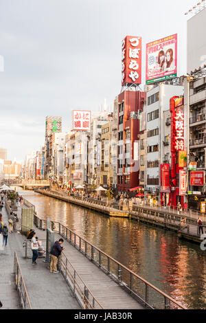 Dotonbori, one of the principal tourist destinations in Osaka. View along busy waterfront from the Ebisu, Dotonbori bridge at twilight, early evening, Stock Photo