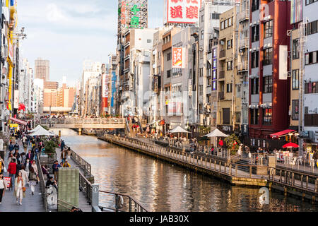 Dotonbori, one of the principal tourist destinations in Osaka. View along busy waterfront from the Ebisu, Dotonbori bridge at twilight, early evening, Stock Photo