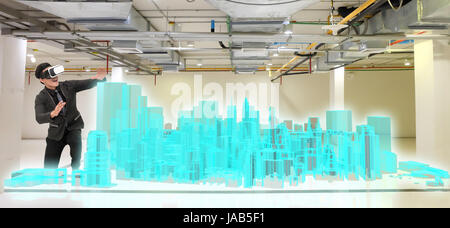Virtual reality technology, hologram and smart city concept. Business man suit wearing VR glasses to see 3d rendering of modern building. Stock Photo