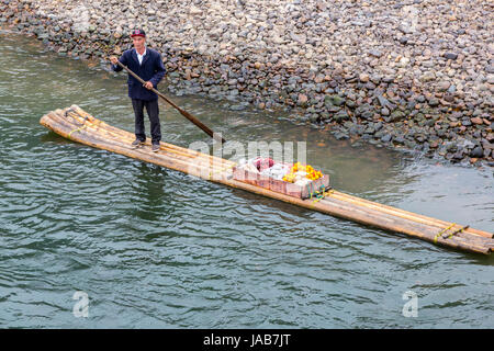 Li River Cruise, Guangxi Region, China.  Boatman Moving Food Supplies Upriver on a Bamboo Raft. Stock Photo