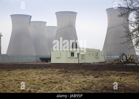 Temporary site cabins in front of the disused cooling towers of Willington Power Station, Derbyshire, UK. The power station was closed in the 1990s Stock Photo