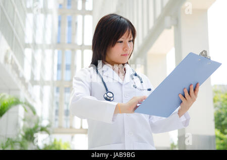 Southeast Asian medical student. Young medical doctor woman standing on hospital background. Stock Photo