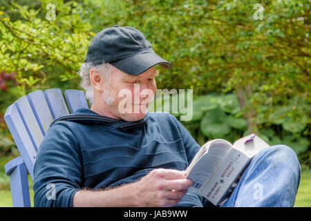 man in chair reading a book Stock Photo