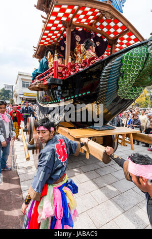 Inuyama festival in Japan, massive 3 storey wooden Dashi float, also called yatai or yama, in city square with spectators and Dashi team members. Stock Photo